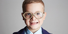 funny smiling child in glasses and siut